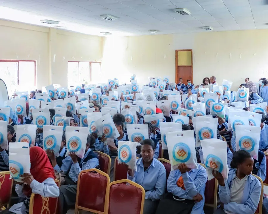 A hall full of schoolgirls receiving dignity kits