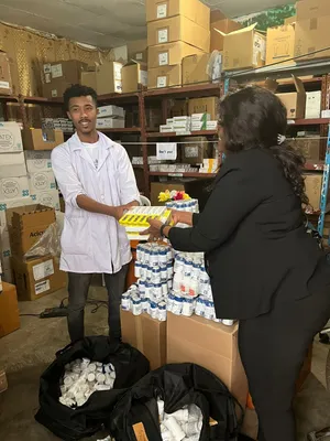 Dr. Yetmwork hands medical supplies to Mekedonia staff